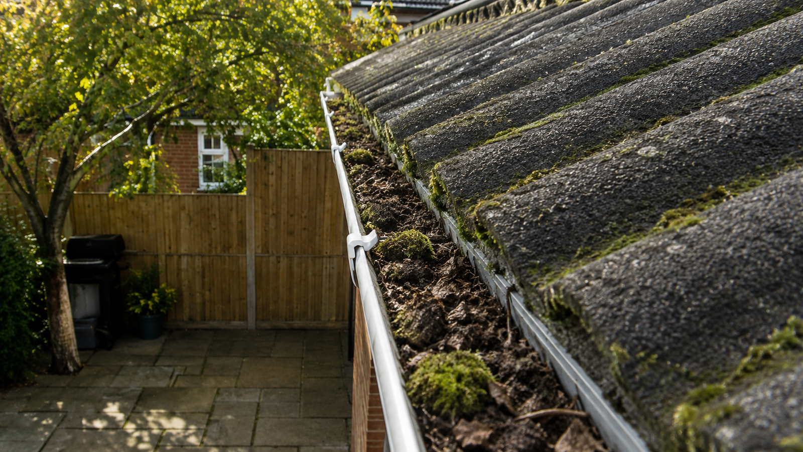 Birmingham gutter before summer health check showing accumulated debris, silt and moss buildup
