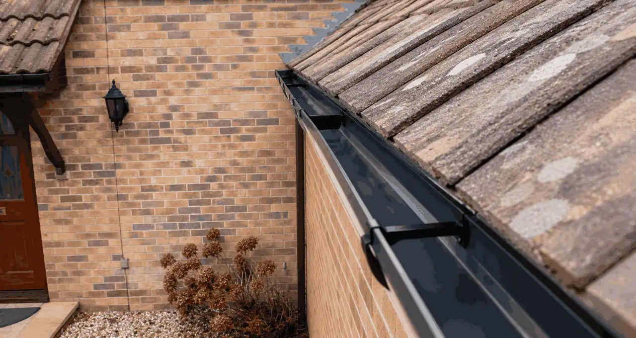 After — Same Birmingham property after professional gutter cleaning — channel fully cleared, downpipe flowing freely, all warning signs resolved