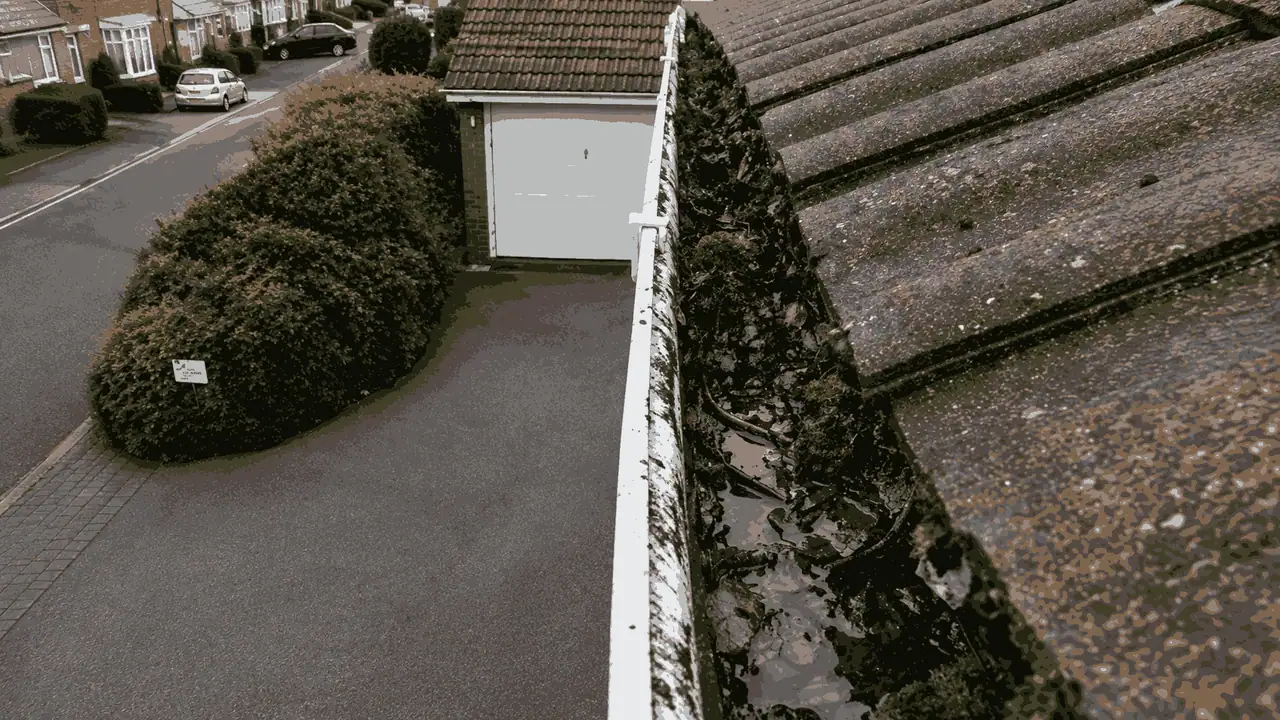 Birmingham gutter before summer inspection showing hidden damage concealed beneath debris and silt