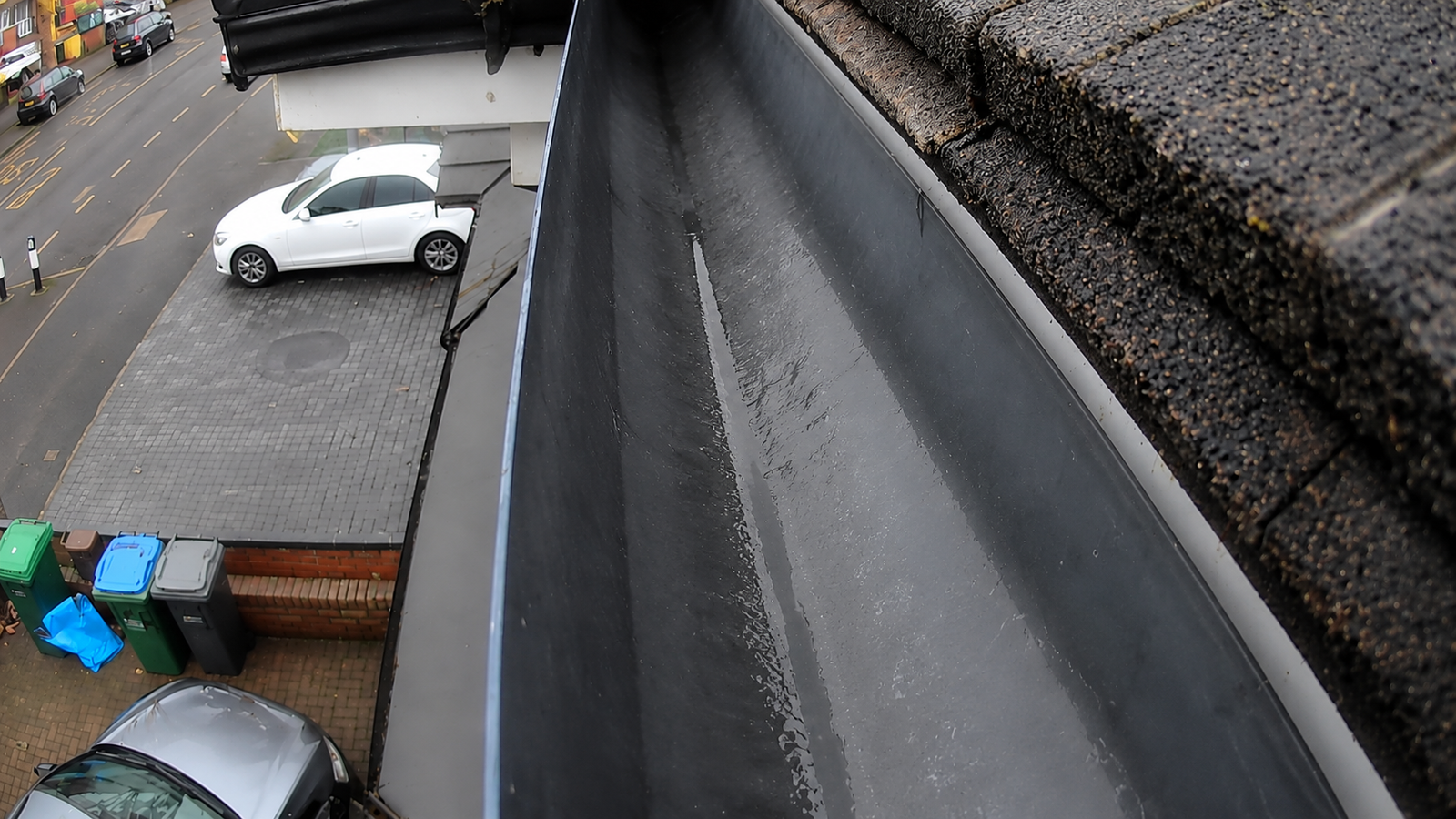 After gutter cleaning in Walsall — gutter fully cleared to the plastic channel, downpipe flowing freely, WOW Gutters